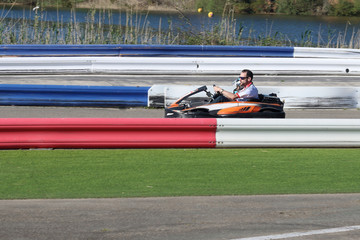 Obraz premium padre e hijo en un kart biplaza en un circuito de carreras