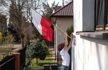 The boy is hanging a flag. Polish National Day of the Third of May, Constitution Day Flag Day,...