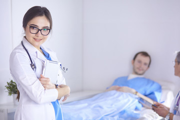 Doctor checking heart beat of patient in bed with stethoscope