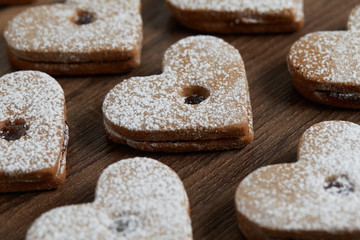 Close up of freshly baked homemade Christmas sugar cookies with jam on a wooden background