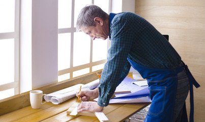Engineer carpenter working on laptop and sketching project