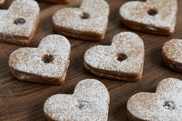 Close up of freshly baked homemade Christmas sugar cookies with jam on a wooden background