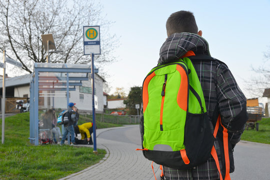 Sch&uuml;ler mit Schulrucksack der Grundschule auf dem morgendlichen Weg zum Schulbus
