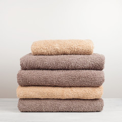 A stack of fresh bath towels folded on the table.