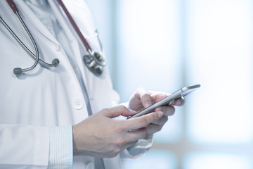 Obraz na płótnie Canvas Medical doctor using smart phone for work in hospital