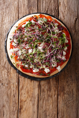 Healthy pizza with feta and mix micro green close-up. Vertical top view