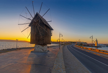 Fototapeta na wymiar Nessebar, Bulgaria, 09 August 2018 - Old windmill at the entrance to the Old Town of Nessebar early in the morning on sunrise, ancient city on the Black Sea coast of Bulgaria.