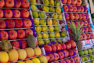 Ripe oriental fruits are on the counter of the oriental bazaar. Pomegranates, melons, mango, papaya, pineapple. Ripe fruit on the counter. Buying ripe fruit in the bazaar.