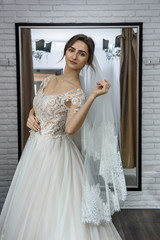 Portrait of young bride in wedding dress in shop