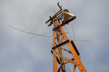 Verrosteter alter Strommast der Bahn mit Kabeln und Lautsprecher