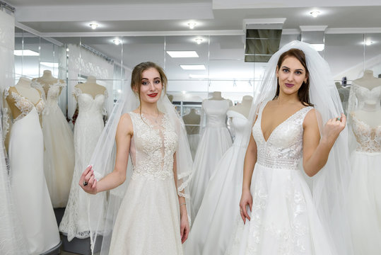Wedding dresses on two pretty women in salon
