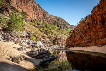 Fototapeta na wymiar Bottom landscape view of Ormiston gorge in the West MacDonnell Ranges with waterhole and cliffs in outback Australia