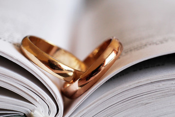 Two wedding rings and a book so close