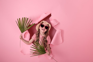 funny little girl in hat and glasses on colored background