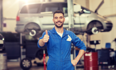 car service, repair, maintenance, gesture and people concept - happy smiling auto mechanic man or...