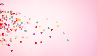 colored Sequin scattered on white background， with pink light