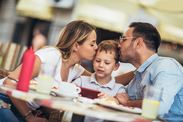 Portrait of happy family spending time in pizzeria