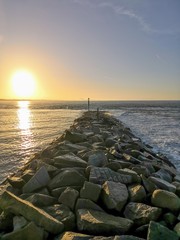 Mer et digue, Normandie, soleil levant.