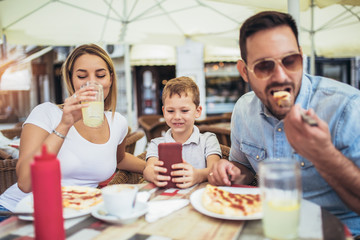 Fototapeta na wymiar Portrait of happy family spending time in pizzeria