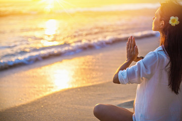 Woman Practicing Lotus Pose on Beach