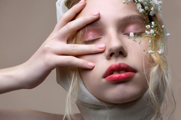 Beautiful model with light pink eyeshades closing eyes while posing