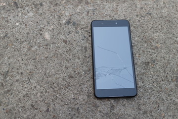 Smartphone mobile fall on the cement floor with touch screen broken.