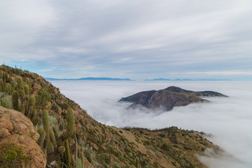 Fototapeta na wymiar Cima de las montañas sobre las nubes, cerro Manquehue