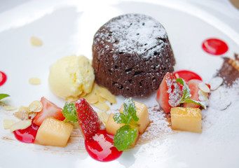 molten chocolate cake with fruits and ice cream top view
