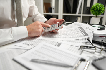 Businessman working at office and calculating finance, reads and writes reports. Business financial accounting concept.