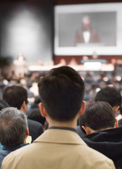 "Conference Speaker in Lecture Presentation Hall. Meeting with Executive Manager Audience in Auditorium.  Corporate Event with Investors Listening to Expert Presenters. Tech Business Training Seminar.