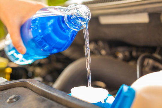 Auto  Service Scheibenwaschanlage auff&uuml;llen mit blauer Fl&uuml;ssigkeit aus Flasche 1