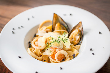 Italian pasta with bacon, tomatoes, cheese, oysters. European cuisine.