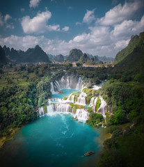 Massive hidden waterfall surrounded by mountain with blue clean water. Paradise on the border between China and Vietnam. Ban gioc waterfall, Detian.	
