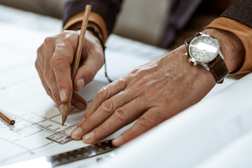 Professional interior designer wearing nice watch holding pencil