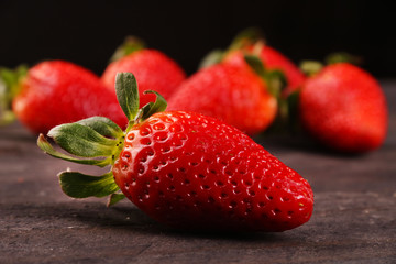 Healthy Heap of fresh strawberries on black wooden background., selective focus