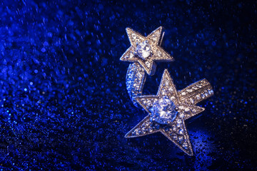elegant ring with star on blue background with water drops