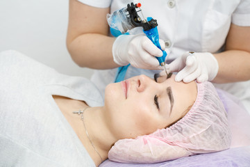 Permanent makeup, tattooing of eyebrows. Cosmetologist applying make up