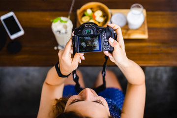 beautiful female photographs her food on camera. foodblogger