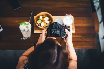 beautiful female photographs her food on camera. foodblogger