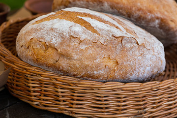 loaf bread round fresh delicious whole-grain brown in a wicker basket close-up