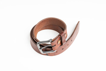 A used men's thick leather brown belt with patina from use deliberately and artistically set on a...