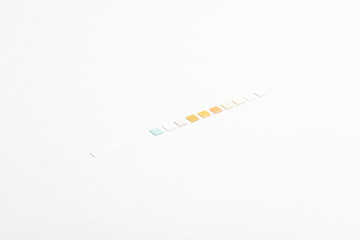 A single unused urine reagent strip for medical testing set on a plain white background.
