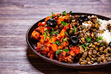 Rice with lentils and vegetables on wooden table