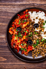 Rice with lentils and vegetables on wooden table