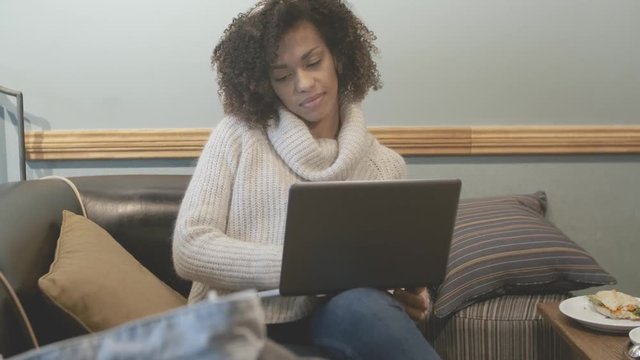 Casual student woman sitting at coffee shop and using laptop