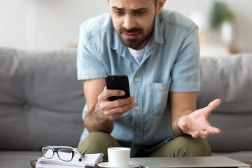 Close up confused man having problem with phone, receive bad news