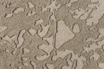 Hintergrund Muster aus nassem und trockenem Sand am Strand in der Brandungszone - Background pattern of wet and dry sand on the beach in the surf zone