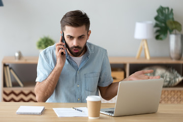 Outraged unhappy businessman talking on phone, unpleasant conversation
