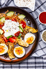 Grilled chicken meat with groats and boiled egg on wooden table