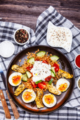 Grilled chicken meat with groats and boiled egg on wooden table